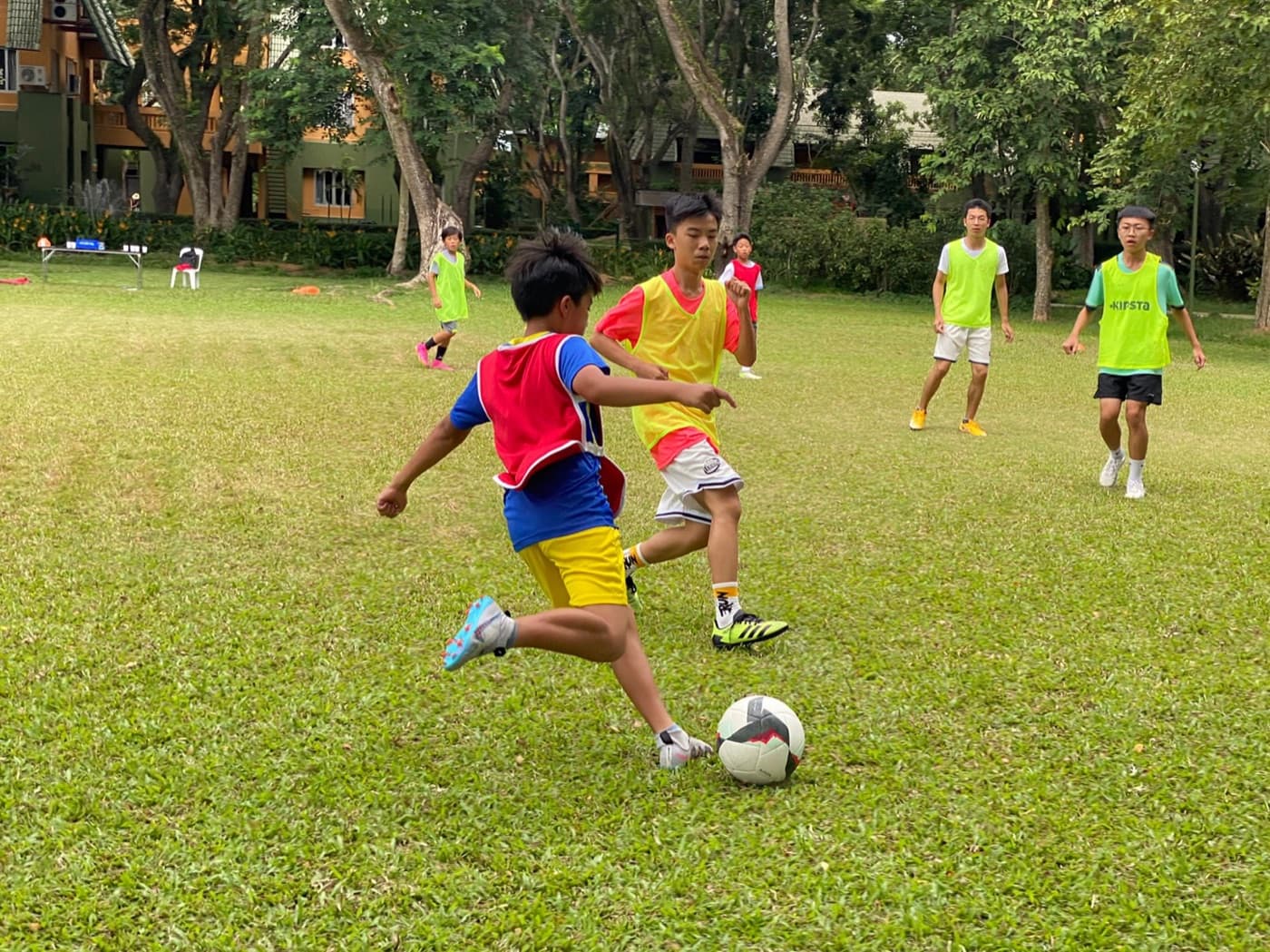 Children playing soccer together at an outdoor camp